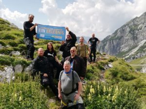 Eine Gruppe Motorradfahrer steht auf einem Berg und freut sich über die Aussicht.
