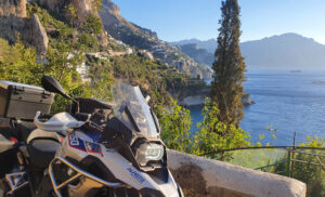Ein BMW Motorrad vor der Kulisse einer Italienischen Küstenstraße.