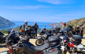 Eine Gruppe Motorradfahrer steht vor der Calanche auf Korsika.